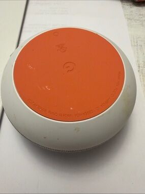 google smart speaker with white body and orange base